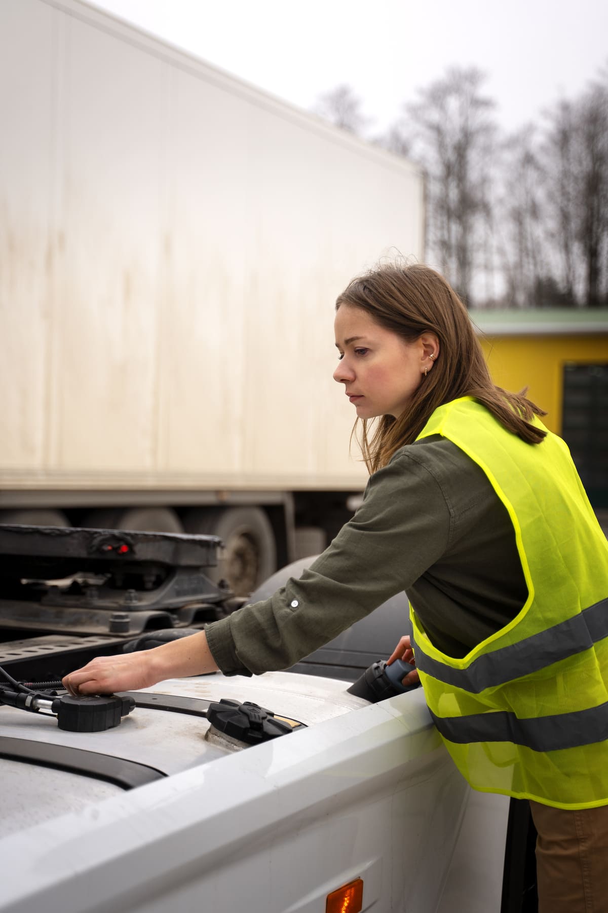 Jeune femme avec un gilet de sécurité en train de déplacer des déchets